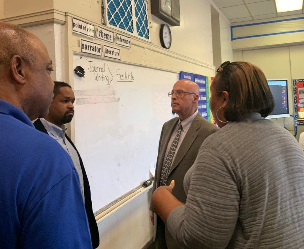 (l to r:) Jerry Jordan, Sharif Street and Arthur Steinberg talk with a PFT member about the impact of lead abatement efforts on her classroom