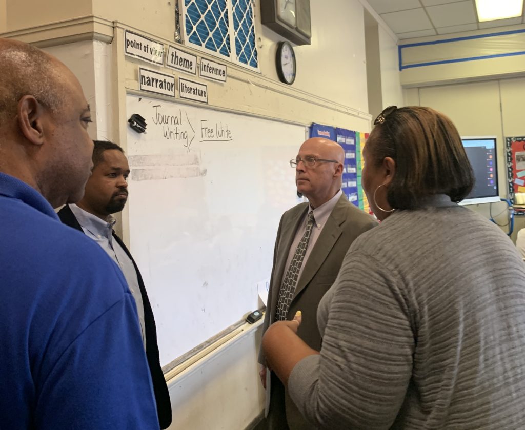(l to r:) Jerry Jordan, Sharif Street and Arthur Steinberg talk with a PFT member about the impact of lead abatement efforts on her classroom
