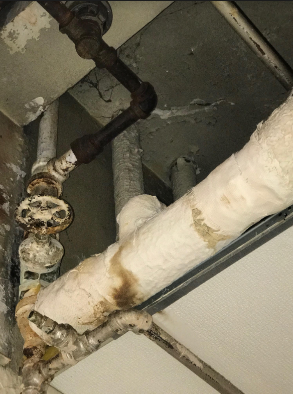 Asbestos insulation in gym – damaged by water leak from above – close look at water impact and repair work conducted
