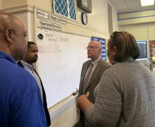 (l to r:) Jerry Jordan, Sharif Street and Arthur Steinberg talk with a PFT member about the impact of lead abatement efforts on her classroom